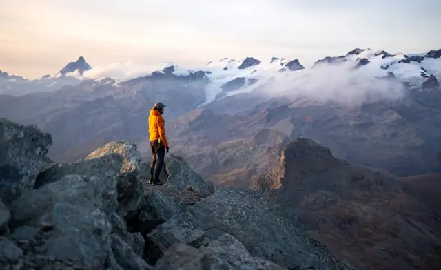 Person steht auf Berg mit Berge im Hindergrund